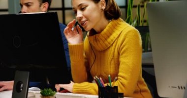 Önden görünüm müşteri hizmet yöneticilerinin ofis masasında kulaklıktaki konuşuyor. Erkek ve kadın kısa saçlı istemcilere konuşuyorsun.