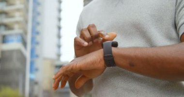 Şehirde smartwatch kullanan adam bölümünü Orta yakın çekim. Ağır çekimde onun smartwatch üzerinde mesajlarını adam.