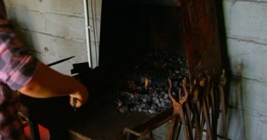 Genç kadın metal el ve at nalı yangında ısıtma aracı yakın çekim. Kadın metal Isıtma at nalı Fabrikası'nda yangında orta bölümü. Elleri ve araç üzerinde Kapat.