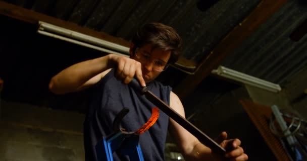 火花を作る工場で輝く熱い蹄鉄を形作る親切な女性鍛冶のローアングル ビュー — ストック動画