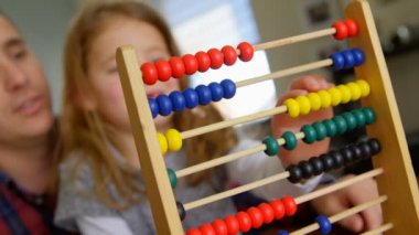 Bir mutlu ve baba ve kızı evde oturma odasında abacus oynamaktan gülümseyen kapatın. Aile oynama ve birlikte vakit.