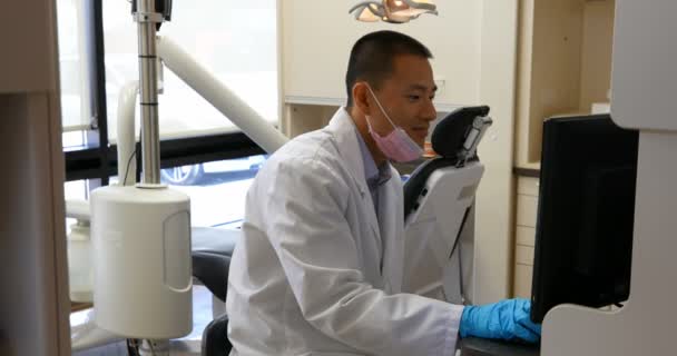 Seitenansicht Eines Lächelnden Männlichen Asiatischen Zahnarztes Mit Weißem Laborkittel Desktop — Stockvideo