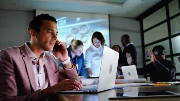 Genç Işadamı Ofiste Dizüstü Bilgisayar Kullanırken Cep Telefonda Konuşurken Yüzey — Stok video