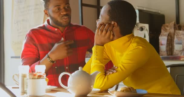 在咖啡馆里互相互动的年轻夫妇的中段 女朋友在听的时候说话的男人 慢动作 — 图库视频影像