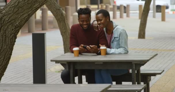 Vista Frontal Pareja Feliz Utilizando Teléfono Móvil Cafetería Aire Libre — Vídeos de Stock