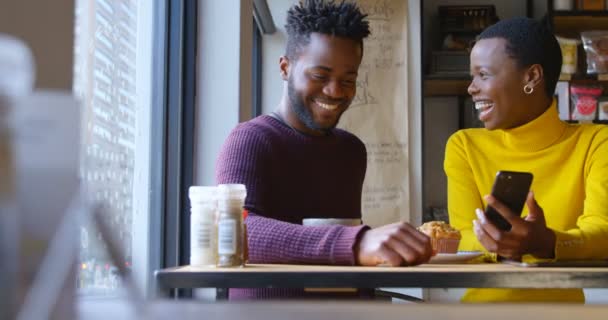 Mutlu Genç Çiftin Birlikte Kafede Cep Telefonu Gülen Çörek Paylaşımı — Stok video
