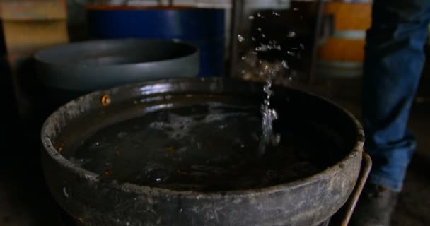 Gros plan d'une jeune métallurgiste femelle enlevant le fer à cheval de l'eau. Le feu en arrière-plan .