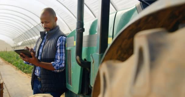 Blueberry Çiftlik Dijital Tablet Kullanırken Traktör Karşı Yaslanmış Düşünceli Etnik — Stok video