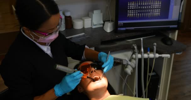 Μεγάλη Γωνία Άποψη Της Γυναικείας Ασίας Οδοντίατρος Εξετάζει Έναν Ασθενή — Αρχείο Βίντεο