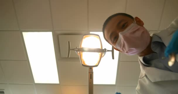 Χαμηλή Γωνία Γκρο Πλαν Του Αρσενικό Οδοντίατρος Εξετάζει Έναν Ασθενή — Αρχείο Βίντεο