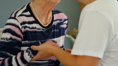 Emekli yaşlı annesi evde oturma odasında öpüşme bir yetişkin oğlu kapatın. Baba Büyükanne elele geziyor.