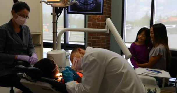 Visão Lateral Dentista Asiático Masculino Examinando Paciente Jovem Com Cuidado — Vídeo de Stock