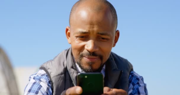 Widok Przodu Szczęśliwego Człowieka Etnicznych Przy Użyciu Telefonu Komórkowego Gospodarstwie — Wideo stockowe