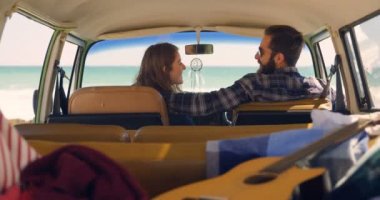Genç çift birbirleri ile etkileşim minibüste güneşli bir günde. Çift roadtrip 4 k eğleniyor