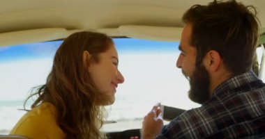 Mutlu genç çift birbirleri ile minibüste etkileşim. Roadtrip 4 k eğleniyor