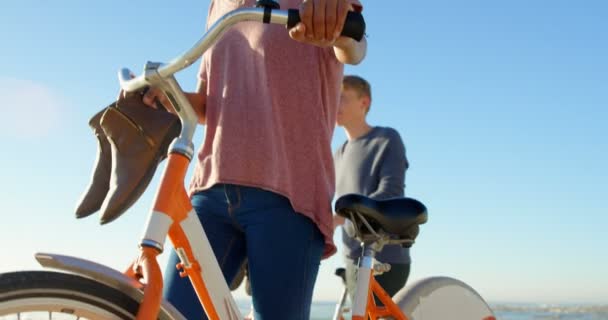 Casal Jovem Caminhando Com Bicicleta Praia Céu Bonito Fundo — Vídeo de Stock