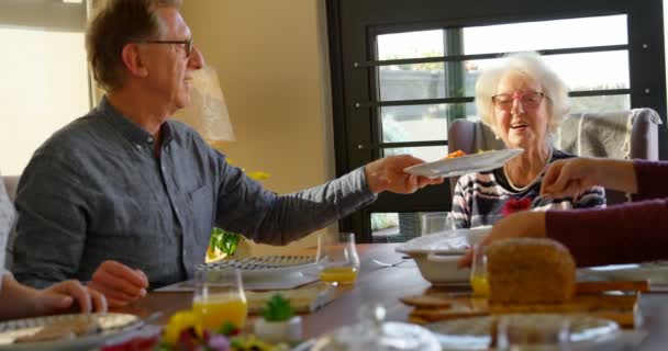 Hombre Mayor Sirviendo Plato Comida Mujer Mesa Comedor Hija Poniendo — Vídeos de Stock