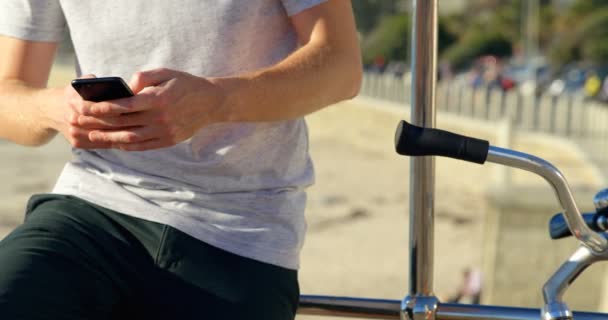 Uomo Con Bicicletta Utilizzando Telefono Cellulare Sulla Spiaggia Sezione Centrale — Video Stock