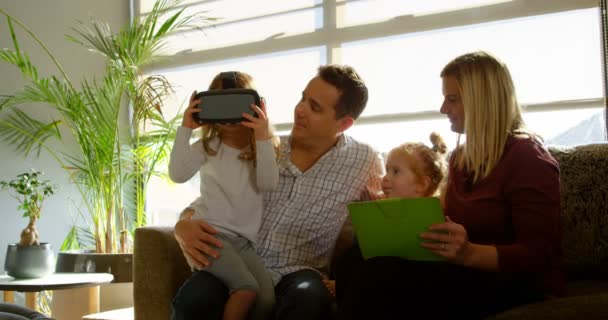 Mädchen Mit Digitalem Tablet Mit Eltern Auf Dem Sofa Hause — Stockvideo