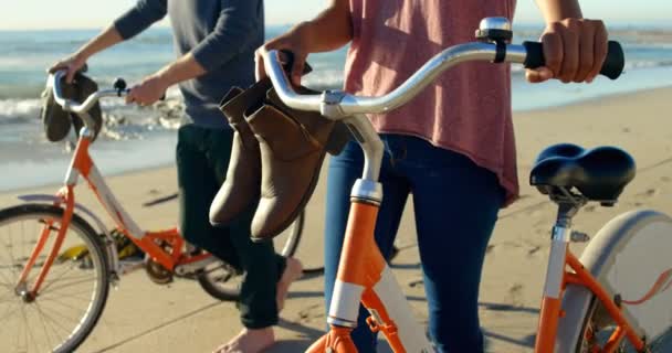 低部分的夫妇与自行车走在海滩上 平静的大海在背景4K — 图库视频影像
