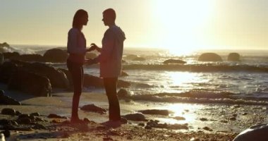 Çift birbirleri ile denize yakın etkileşim. Günbatımı içinde belgili tanımlık geçmiş 4k