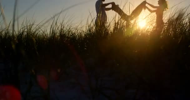 Silhueta Casal Jovem Sacudindo Cobertor Piquenique Praia Belo Pôr Sol — Vídeo de Stock