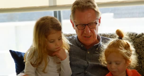 Ενεργό Παππού Που Αλληλεπιδρούν Εγγόνια Στο Σπίτι Παιδιά Κάθονται Στην — Αρχείο Βίντεο