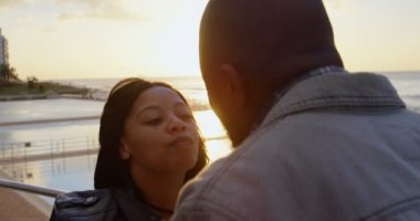 Romantik Çift birbirlerine güneşli bir günde öpüşme. Güzel gökyüzü ve denizin içinde belgili tanımlık geçmiş 4k