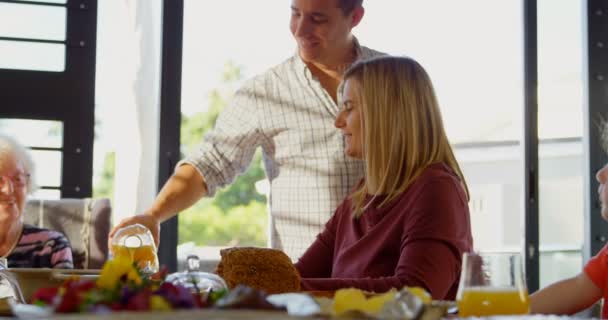 Feliz Hombre Vertiendo Jugo Vidrio Sobre Mesa Comedor Mujer Viendo — Vídeo de stock