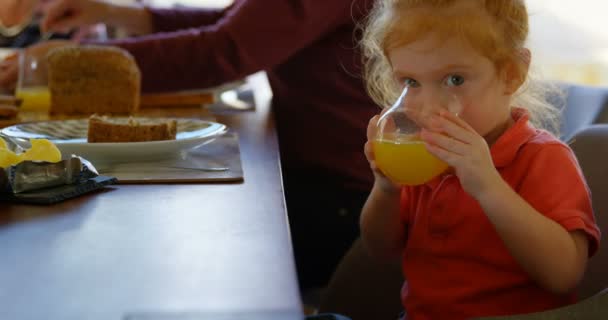 Bel Bambino Che Beve Succo Arancia Tavola Guardando Fotocamera Mentre — Video Stock