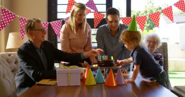 家族のリビング ルームで誕生日ケーキを飾るします 楽しんで一緒に — ストック動画