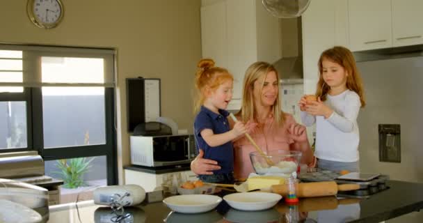 可爱的兄弟姐妹帮助母亲准备面团在厨房 母亲教女儿在烤4K 的时候打破鸡蛋 — 图库视频影像