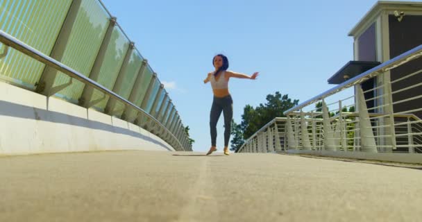 若い女性ダンサーの踊りの街の橋の上 の背景の青い空 — ストック動画