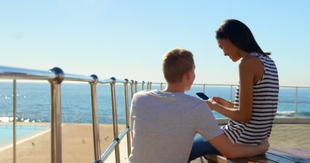 Feliz Pareja Joven Interactuando Entre Mientras Utiliza Teléfono Móvil Cerca — Vídeos de Stock