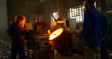 Erimiş metal kalıp Atölyesi'nde dökme işçilerin grup. İşçilerin birlikte 4 k çalışma