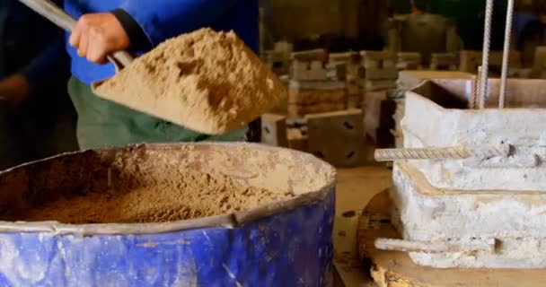 労働者は鋳造ワーク ショップで金型内に土を入れてします のシャベルを使用してワーカー — ストック動画