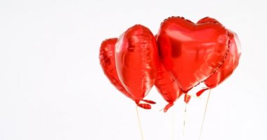 Kırmızı balonlar havada yüzer. Balonlar dize 4 k bağlı kalp şeklinde