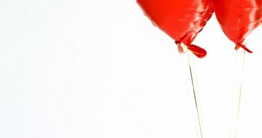 Kırmızı balonlar havada yüzer. Balonlar dize 4 k bağlı kalp şeklinde