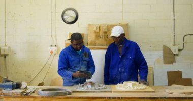 Male workers using digital tablet in workshop. Male workers working together in workshop 4k
