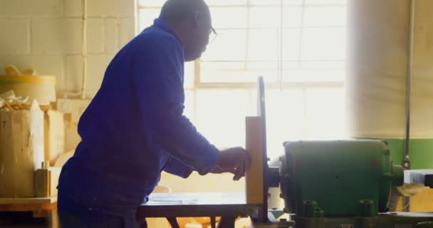 男性労働者ワーク ショップで木製ブロックを切削 のワーク ショップで木製パレット カッター マシン — ストック動画