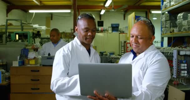 男工人在玻璃厂的笔记本电脑上讨论 在玻璃厂工作的工人4K — 图库视频影像