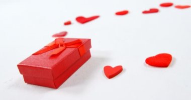 Kırmızı hediye kutusu ve kırmızı kalpler beyaz yüzey. Sevgililer günü kavramı 4k