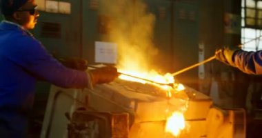 İşçiler fırın atölyede metal kaldırılıyor. Erimiş metal fırın 4k