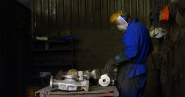 Erkek işçi değirmeni makinasıyla atölyede. Erkek işçi 4 k döküm metal şekillendirme