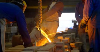 Erimiş metal kalıp Atölyesi'nde dökme işçilerin grup. İşçilerin birlikte 4 k çalışma