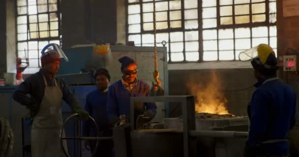 溶解鋳造ワーク ショップで金属の労働者 コンテナー で金属を溶融 — ストック動画