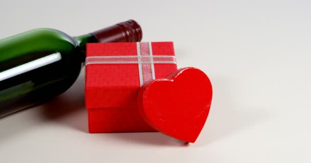 Weinflasche Geschenkbox Und Rotes Herz Auf Weißer Oberfläche Valentinstag Konzept — Stockvideo