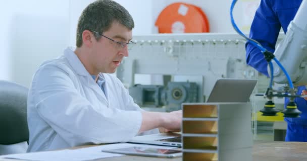 Robotic Engineers Examine Robotic Machine Warehouse Colleague Using Laptop — Stock Video