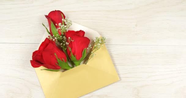Otevřel žlutou obálku s červenou růží na bílém pozadí dřevěná. Valentines day koncept 4k