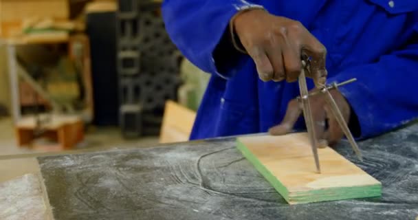 鋳物ワーク ショップのテーブルでの作業 木の板 の幾何学のコンパスを使用してワーカー — ストック動画